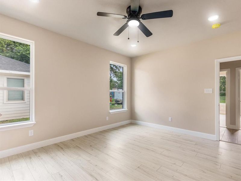 Spare room featuring light wood-style floors, a ceiling fan, recessed lighting, and a smoke detector Spare room featuring light wood-style floors, a ceiling fan, recessed lighting, and a smoke detector