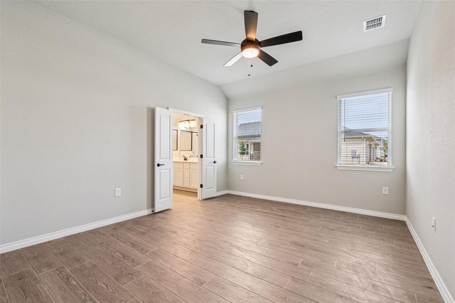 Unfurnished bedroom featuring wood finished floors, baseboards, ensuite bathroom, a ceiling fan, and a sink Unfurnished bedroom featuring wood finished floors, baseboards, ensuite bathroom, a ceiling fan, and a sink