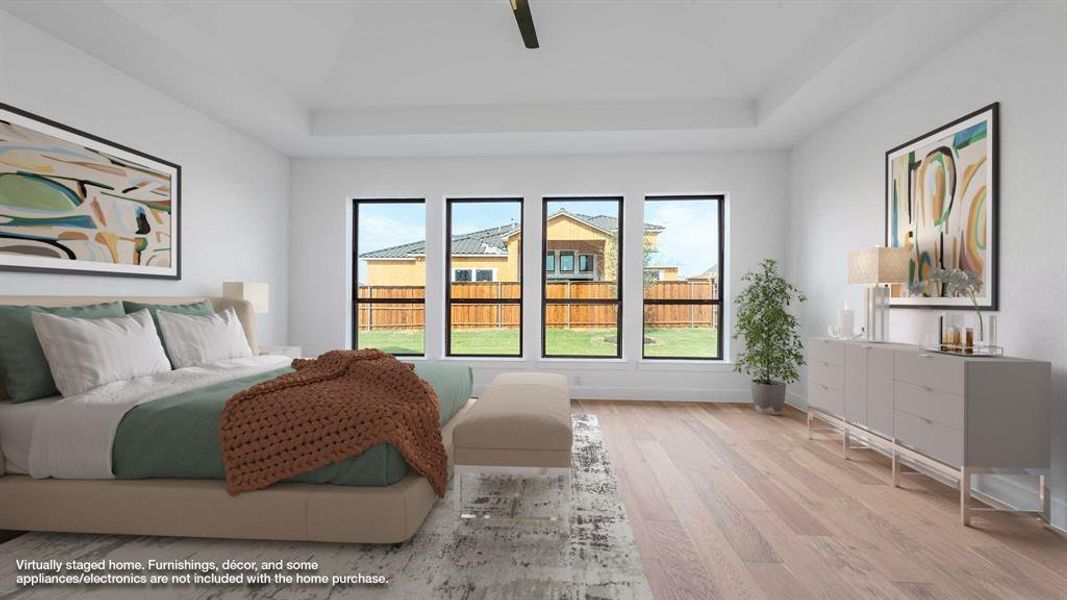 Bedroom featuring ceiling fan, a raised ceiling, and light wood-type flooring