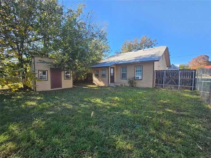 Back of house featuring an outdoor structure and a yard Back of house featuring an outdoor structure and a yard