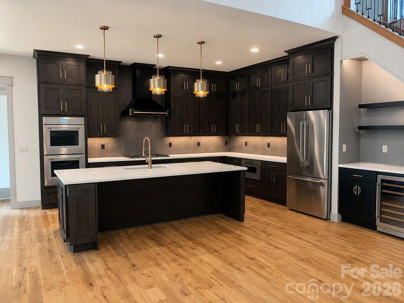 Designer kitchen featuring custom cabinetry, oversized island, and premium finishes