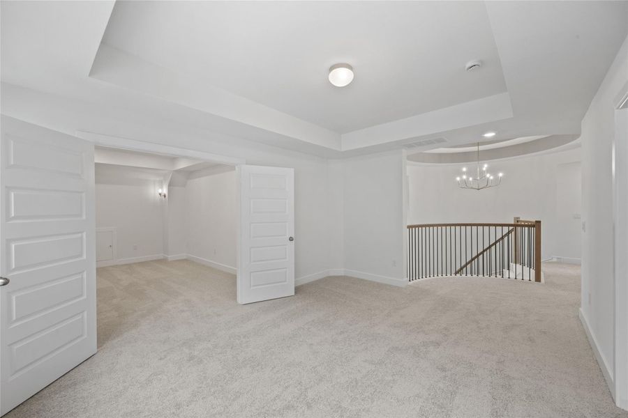 Basement featuring light carpet and a chandelier Basement featuring light carpet and a chandelier