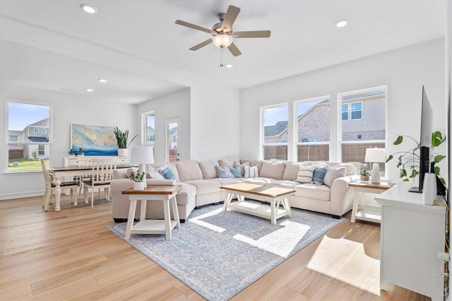 Open-concept living area featuring wood-finish flooring, recessed lighting, and a ceiling fan