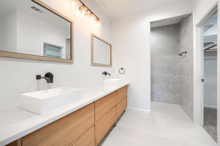 Bathroom with double vanity, a walk in closet, and walk in shower