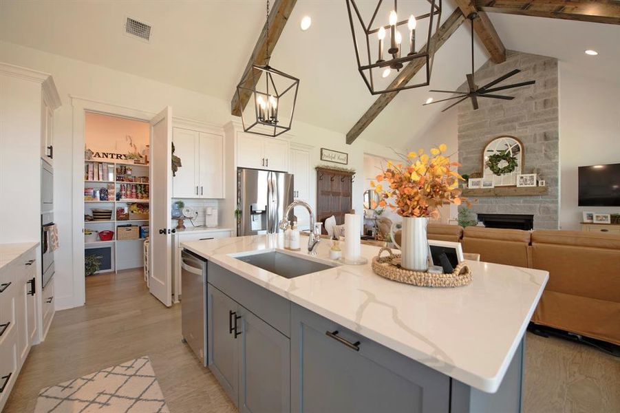 Kitchen featuring gray cabinetry, decorative light fixtures, beam ceiling, a chandelier, and white cabinets