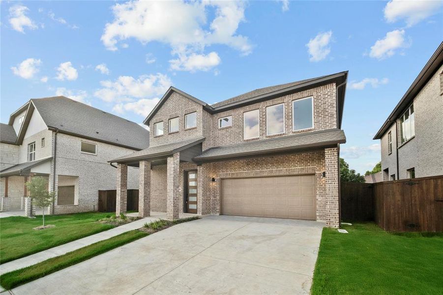 View of front facade featuring brick siding, a garage, driveway, and roof with shingles