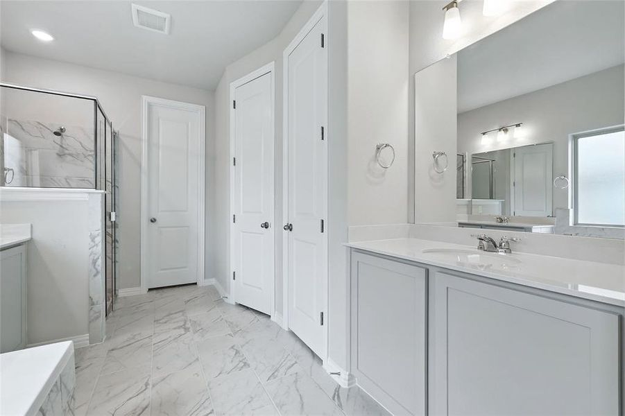 Full bath with vanity, a marble finish shower, and marble finish floors Full bath with vanity, a marble finish shower, and marble finish floors