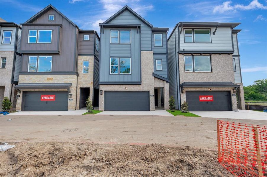 Modern townhome exterior featuring stone and horizontal siding accents Modern townhome exterior featuring stone and horizontal siding accents