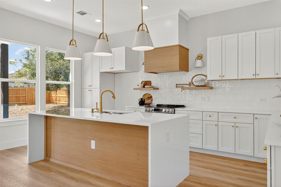 Kitchen featuring decorative backsplash, light stone counters, white cabinets, and recessed lighting