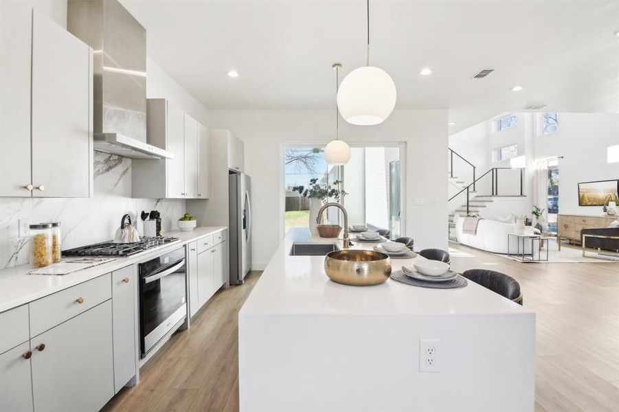 Kitchen with pendant lighting, a kitchen island, stainless steel appliances, decorative backsplash, and sink