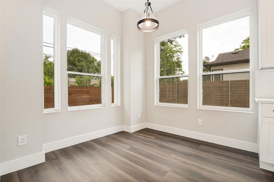 Bright interior space featuring wood-finish flooring, white baseboards, and neutral wall tones