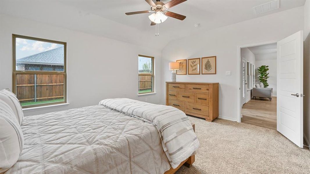 Bedroom with light colored carpet, a ceiling fan, and lofted ceiling