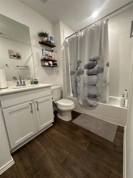 Full bathroom featuring shower / tub combo, vanity, and dark wood-type flooring