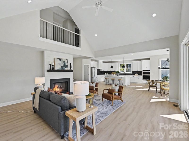 Vaulted ceilings, expansive windows, and an open-concept design fill the stunning great room with natural light while seamlessly connecting the living, dining, and kitchen spaces for effortless entertaining.