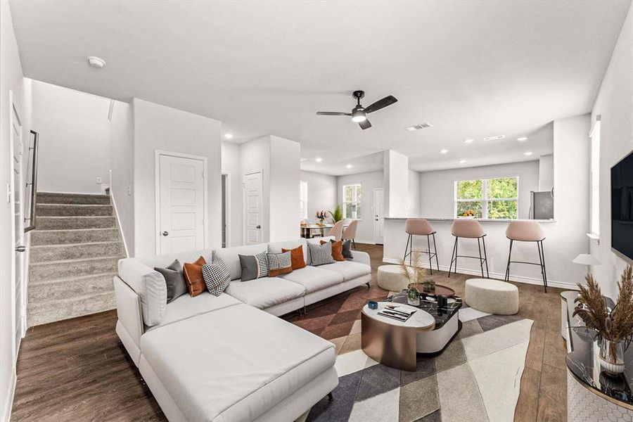 Living room with dark wood-type flooring, stairway, recessed lighting, and a ceiling fan Living room with dark wood-type flooring, stairway, recessed lighting, and a ceiling fan
