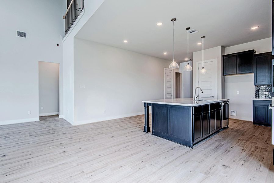 Open-concept floorplan with soaring ceilings and continuous wood-look flooring creates an ideal space for entertaining and everyday living. Open-concept floorplan with soaring ceilings and continuous wood-look flooring creates an ideal space for entertaining and everyday living.