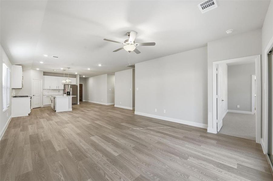 Unfurnished living room featuring a chandelier, recessed lighting, ceiling fan, and light wood finished floors
