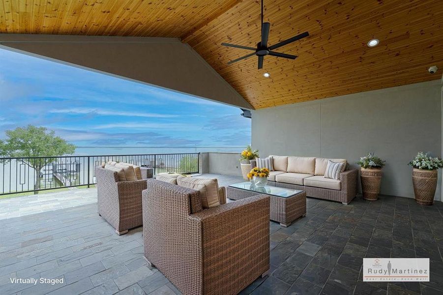 View of patio with a ceiling fan, an outdoor living space, and a water view