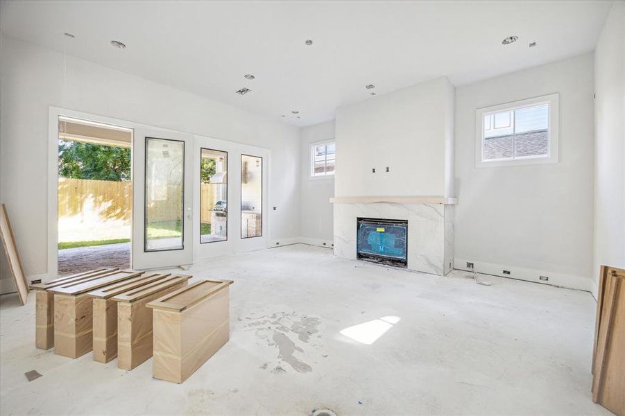 Living room with door leading to outdoor covered patio. Estimated completion date of construction - January 15, 2025.