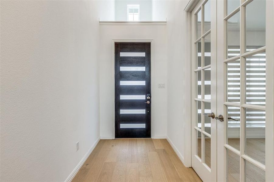 Foyer entrance with light wood-type flooring and french doors