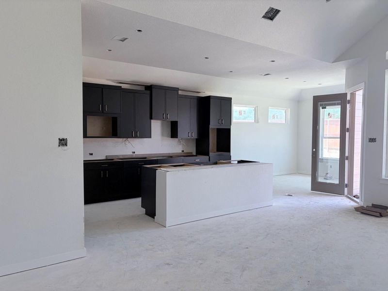 A spacious, open-concept kitchen, primed for customization with dark cabinetry and a central island. A spacious, open-concept kitchen, primed for customization with dark cabinetry and a central island.