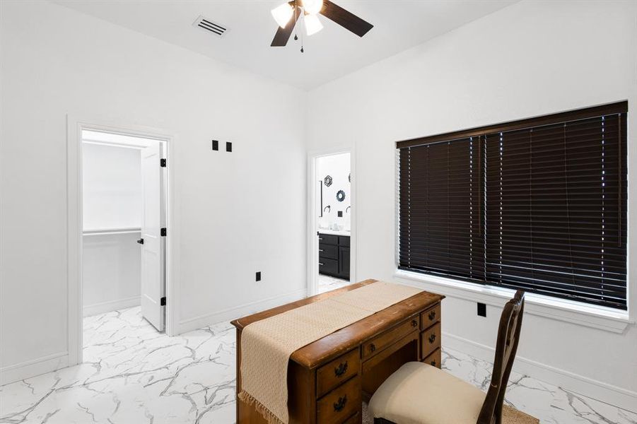 Office with light marble finish floors and a ceiling fan