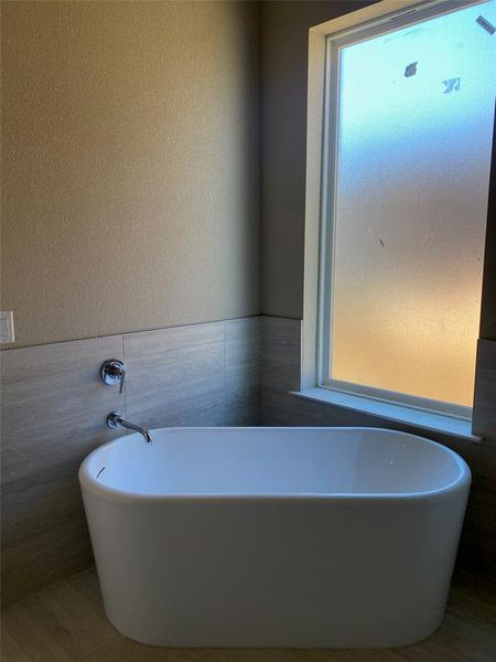 Bathroom with tile walls and a bathing tub