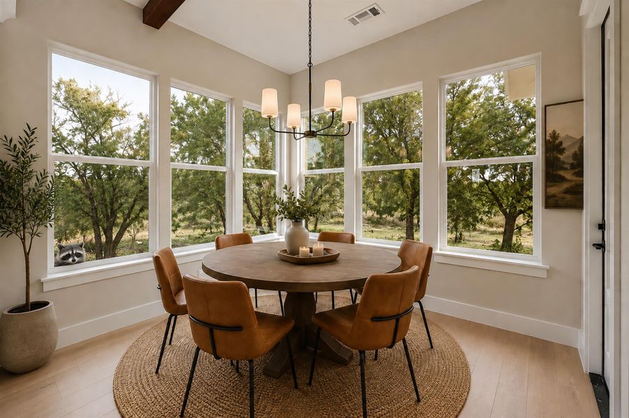 Hardwood floors and towering windows frame views of the surrounding trees in this dining area. Hardwood floors and towering windows frame views of the surrounding trees in this dining area.