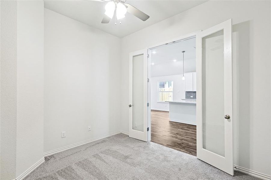 Unfurnished bedroom featuring light colored carpet and ceiling fan