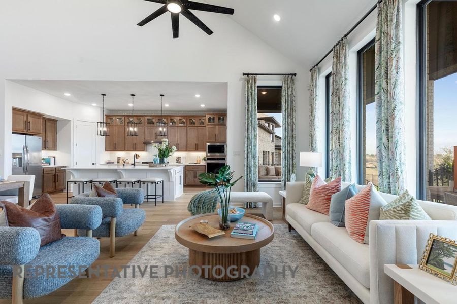 Living area featuring ceiling fan, high vaulted ceiling, light wood-style flooring, and recessed lighting