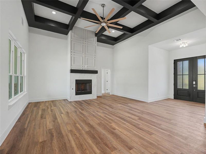 Expansive living area with a coffered ceiling and a large ceiling fan
