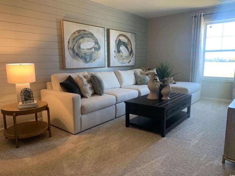 Living area with carpet flooring and wooden walls