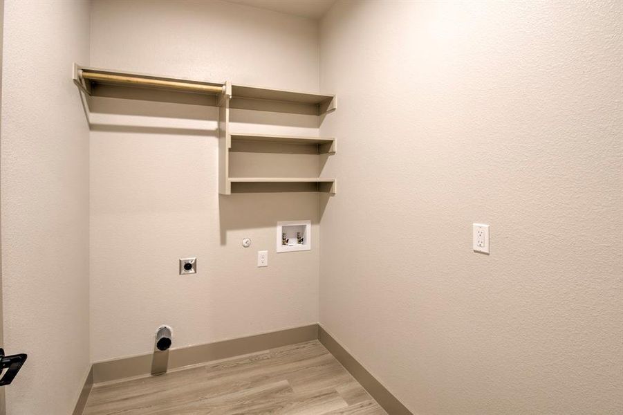 Laundry area with electric dryer hookup, gas dryer hookup, light wood-style flooring, and hookup for a washing machine