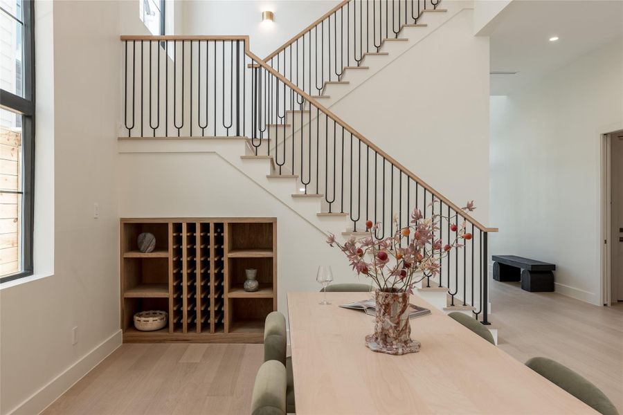 The custom oak staircase becomes an architectural centerpiece, with its modern railing system rising above the built in wine cove and adding definition to the dining room’s dramatic vertical scale. The custom oak staircase becomes an architectural centerpiece, with its modern railing system rising above the built in wine cove and adding definition to the dining room’s dramatic vertical scale.