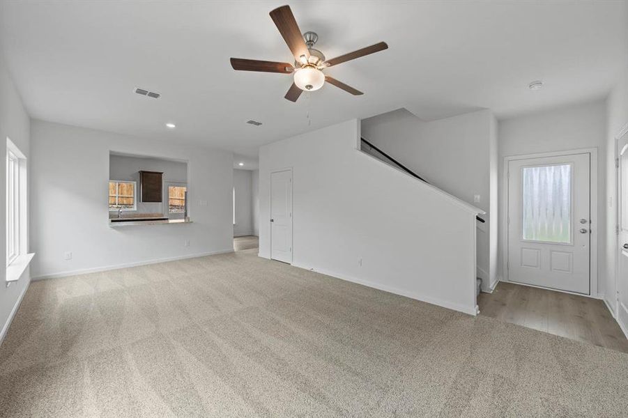 Living room featuring light carpet and ceiling fan