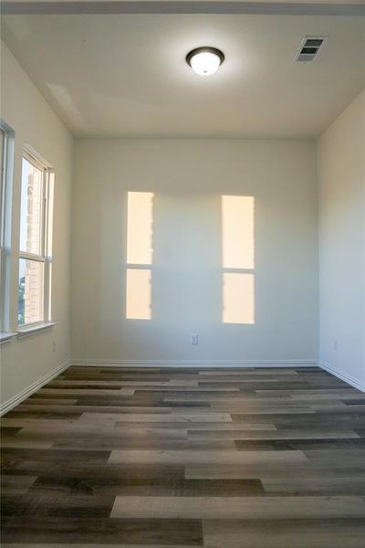 Empty room with dark hardwood / wood-style flooring