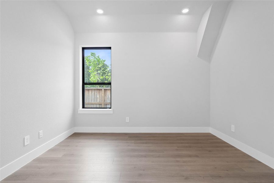 Elevate your work-from-home experience in the study. Double glass French doors open to a light-filled workspace featuring sloped ceilings and recessed lighting, large window, and durable laminate flooring. Whether used as a quiet library or a high-tech command center, this versatile space is designed for both focus and inspiration.