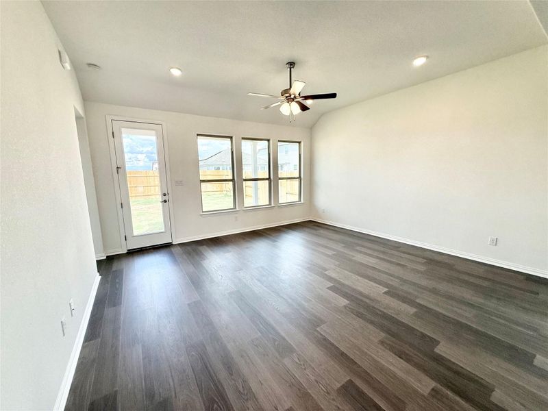 Unfurnished living room featuring dark wood-type flooring, ceiling fan, lofted ceiling, and recessed lighting Unfurnished living room featuring dark wood-type flooring, ceiling fan, lofted ceiling, and recessed lighting