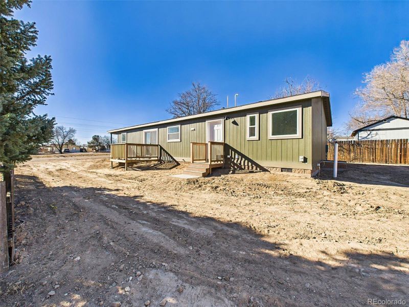 Back Exterior View – A wide-angle look at the home’s back side shows two separate deck areas, fresh exterior siding, and a spacious yard ready for customization.