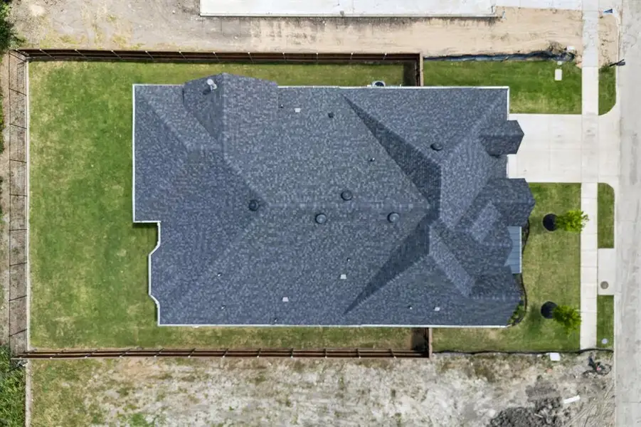 New construction property featuring a complex gray shingle roofline, manicured lawn, and concrete driveway New construction property featuring a complex gray shingle roofline, manicured lawn, and concrete driveway