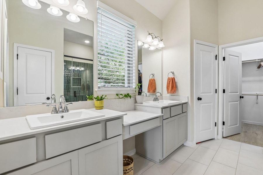 Dual vanities with ample counter space create a functional and orderly primary bathroom.