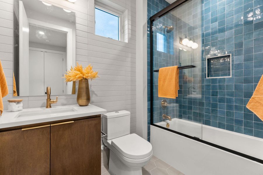 Full bath featuring enclosed tub / shower combo, toilet, vanity, and tile patterned floors