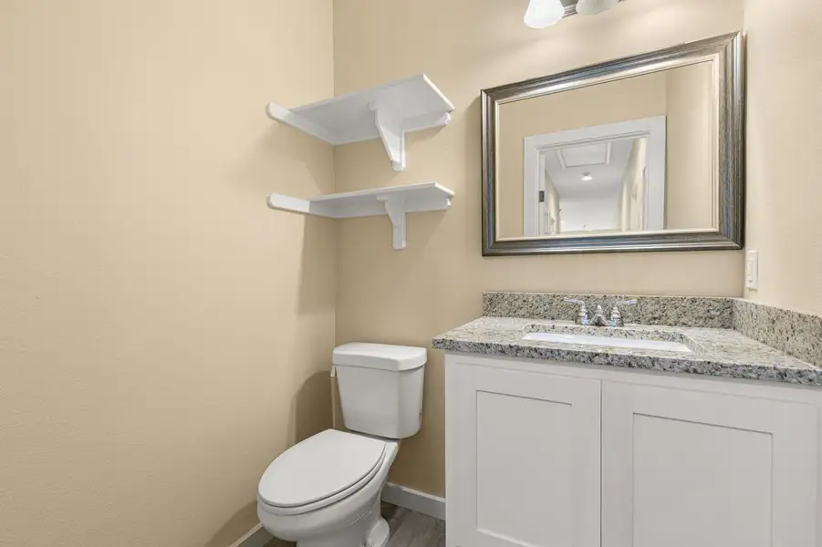 Half bath with vanity and wood finished floors