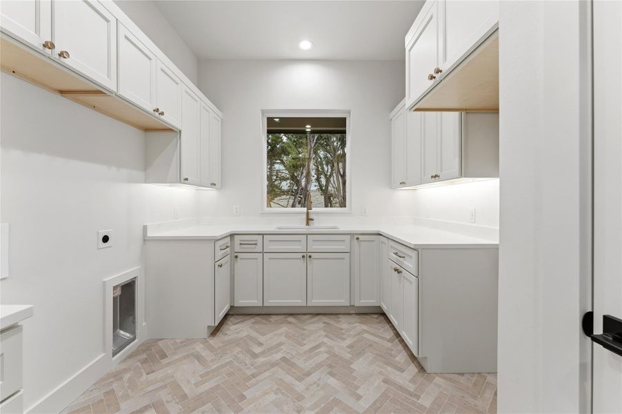 Laundry room with electric dryer hookup, cabinet space, and recessed lighting