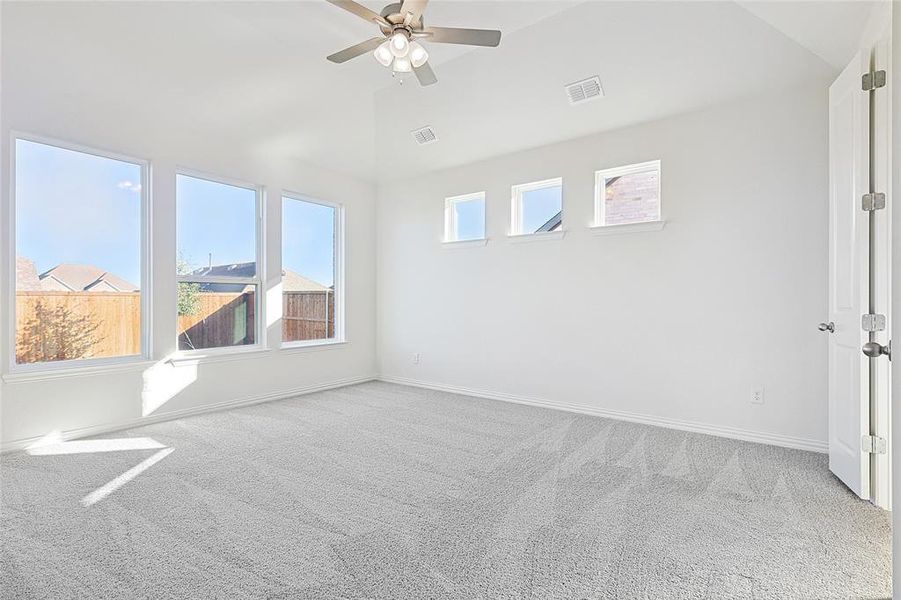 Unfurnished room with carpet flooring, vaulted ceiling, and ceiling fan