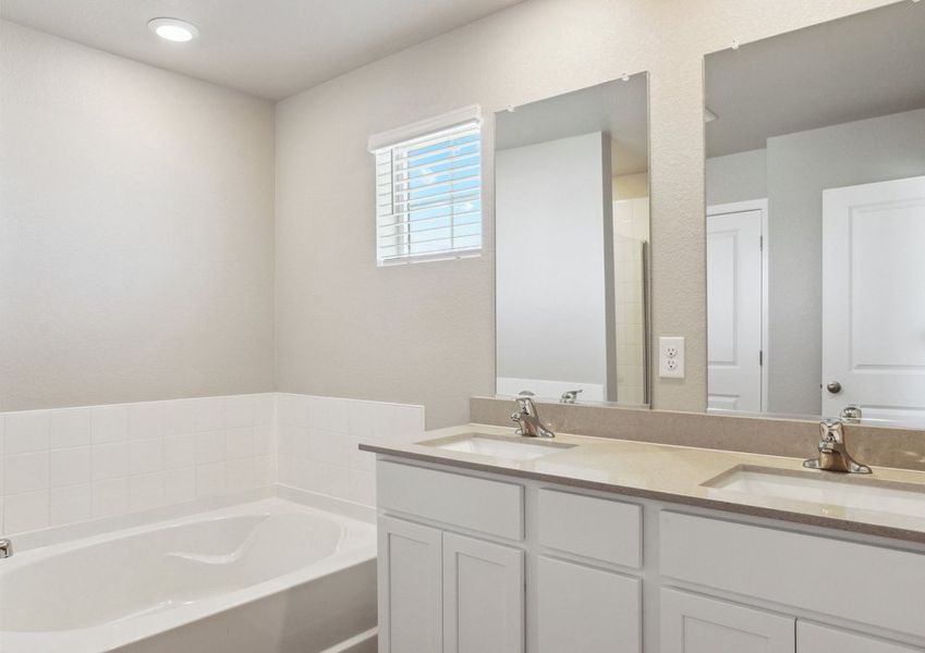 The master bathroom has a large vanity and a soaking tub and step in shower.