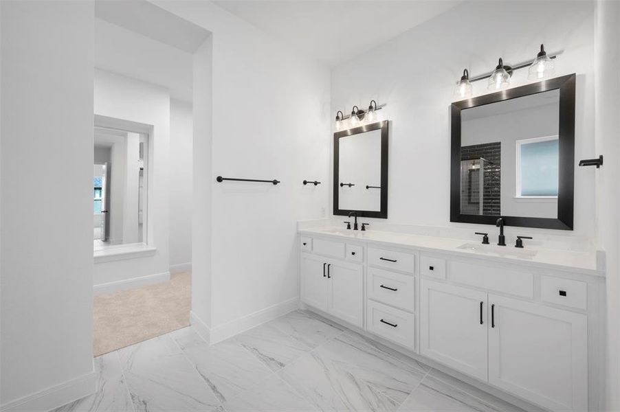Full bathroom featuring light marble finish floors, double vanity, and a stall shower