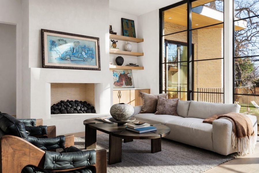 Living area with expansive windows, a fireplace, and a high ceiling