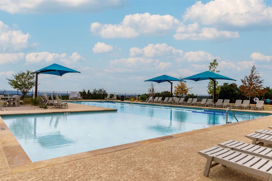 An inviting outdoor pool with a view, framed by vibrant umbrellas and comfortable loungers.