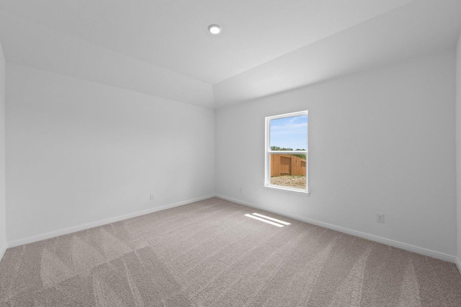 Unfurnished room featuring light carpet and vaulted ceiling